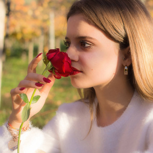 一个女孩在圣情人节嗅到一朵红玫瑰