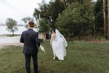 快乐的年轻新婚夫妇在他们的婚礼上散步户外