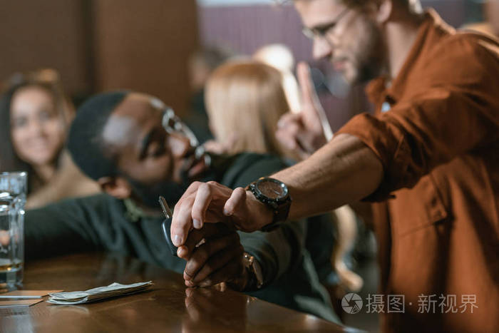 白人男子从他的醉酒的非洲裔美国人的朋友在酒吧的汽车钥匙