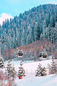 滑雪缆车和雪覆盖的山与松树的背景在霍什布拉克, 哈萨克斯坦的度假村