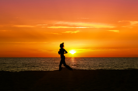 健康的女人在日落时跑步