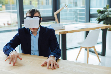 愉快的英俊男子,把他的手放在桌子上照片