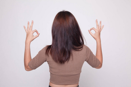 亚洲女人的背视图显示双 Ok 手势