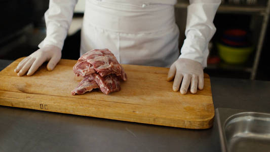 特写的专业厨师准备在餐厅厨房砧板上的肉排骨