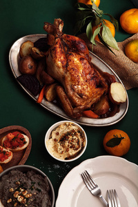 传统的晚餐与烤鸡肉, 颈部和西红柿 bruschettas 在深绿色背景。开销视图。家庭聚餐概念