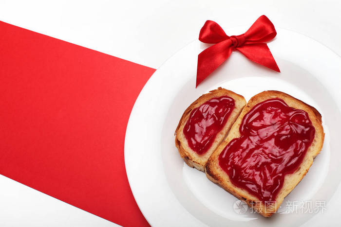 香脆的美味烤面包在白色的盘子上有果酱的形状白色背景红色宽条纹顶部