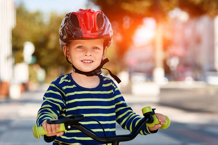 快乐的小男孩骑自行车在城市公园