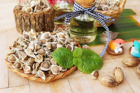 辣木油和种子上木背景照片