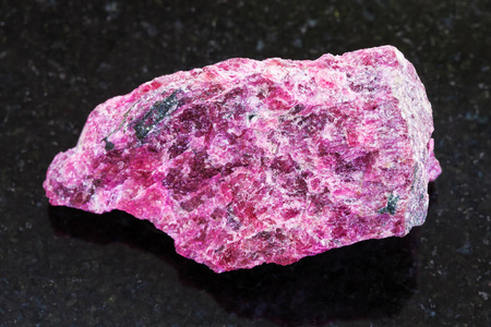 原始的 Eudialyte 石头在黑暗的背景