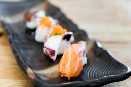 日本原料三文鱼寿司和新鲜混合寿司设置在黑版
