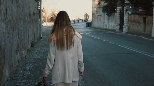 一个的金发女人,留着长头发的背影背影年轻长发女子的头发坐在海滩上