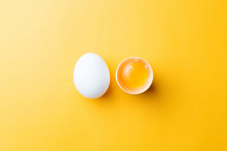 黄色背景下的蛋清和蛋黄。视