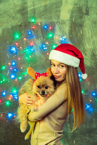 一个女孩在圣诞节帽子与狗博美博美