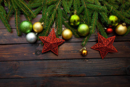 新的一年的绿色, 黄色和银色的球连同红色的星星, 并与活杉木分行在一个木制的背景。顶部视图