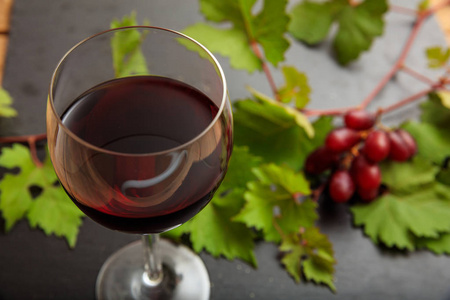 黑底红葡萄酒杯及新鲜葡萄