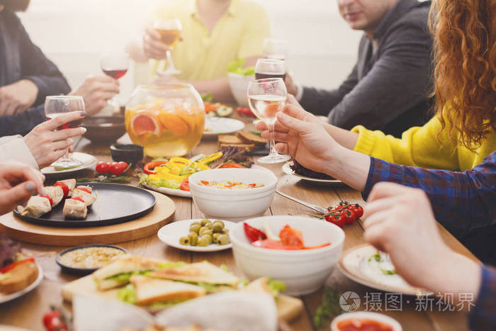 人们吃健康的食物和饮料酒服务的表晚餐聚会