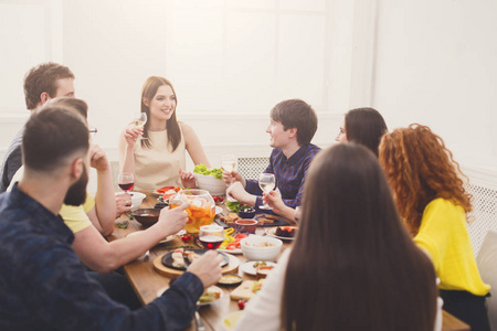 群快乐的年轻人在餐桌旁,朋友聚会聊天照片