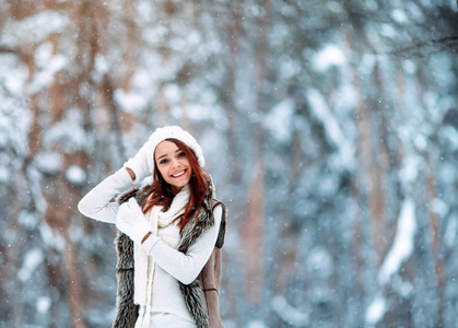 白色衣裳的美丽的女孩有乐趣室外在冬天森林在雪花之下