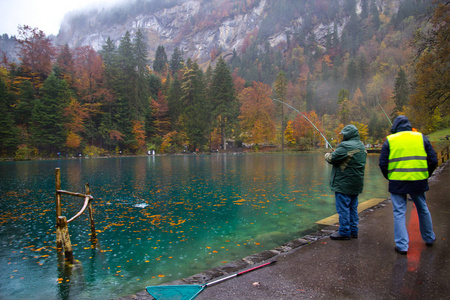 在瑞士 Blausee 湖钓鱼的游客