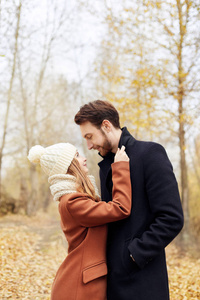 爱的情侣在公园里漫步在秋天的拥抱和亲吻。秋天