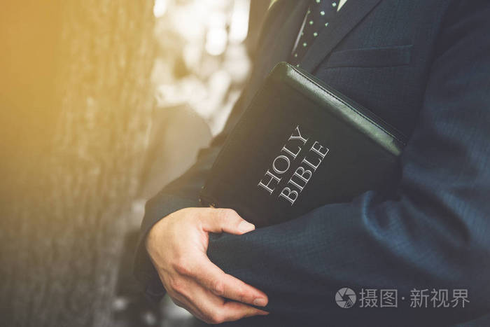 年轻男子手持圣经侧视图