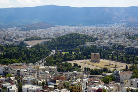 从雅典卫城显示古代废墟 楼宇建筑 城市街道 绿树和山背景的雅典城的景色
