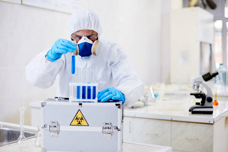 在现代实验室进行实验时佩戴套装和呼吸生物危害物质的天才病毒学研究科学家