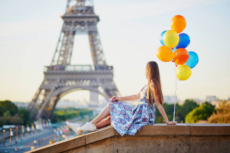 束的气球在埃菲尔铁塔附近的年轻女子