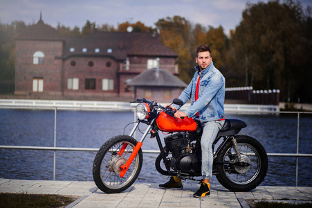 年轻的体育时尚男子骑摩托车, 一个温暖的镜头, 深秋