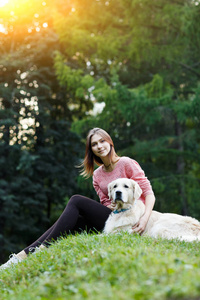 图片从下面的妇女坐在绿色的草坪上的狗
