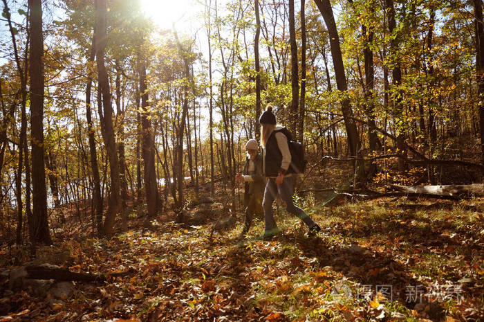 女孩们在山中的秋天森林里漫步徒步旅行