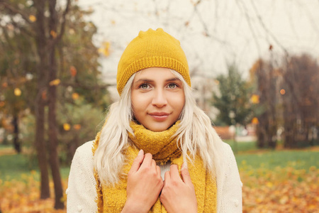 可爱的秋天妇女时装模型与黄色围巾和帽子
