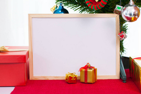 木制相框与圣诞装饰在红地毯上。红