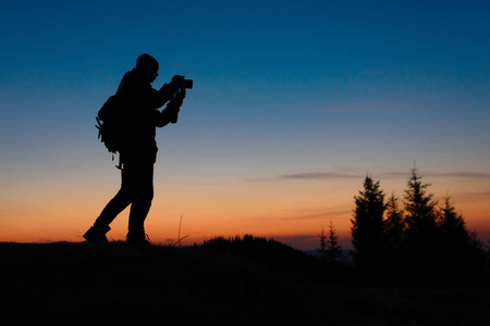 摄影师在室外日落时使用照相机