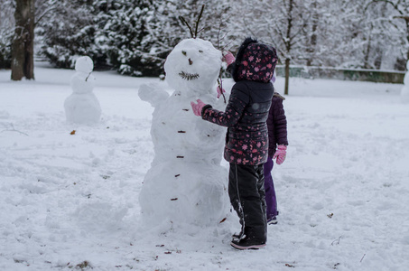 快乐的孩子在公园里享受冬天的气氛在雪地里玩耍, 堆雪人