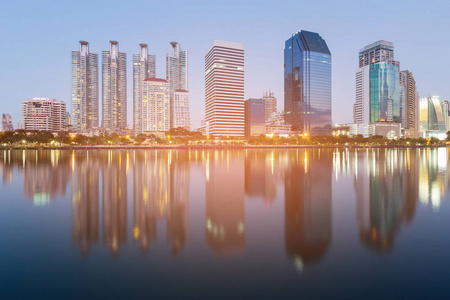 夜办公楼与反射在蓝色黄昏, 都市风景市中心背景