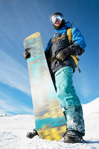 一个专业的滑雪站在他的滑雪板上对蓝天