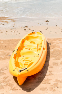 黄色的塑料皮艇躺在海边的沙滩上