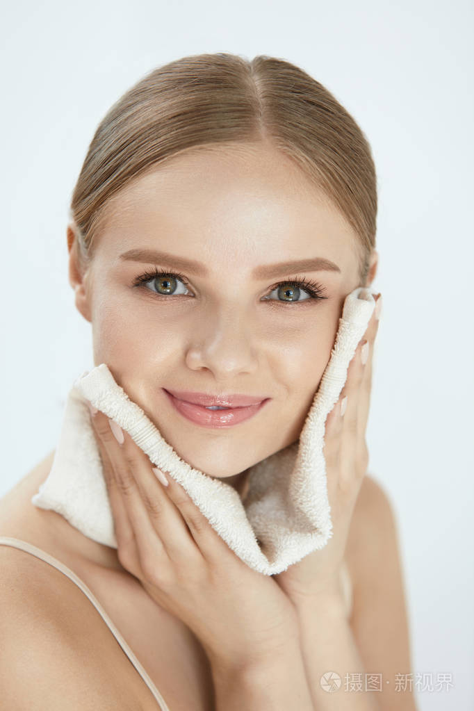 女人用白毛巾清洁脸部皮肤