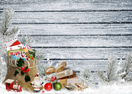 圣诞贺卡带礼物, 一袋信件, 圣诞老人, 玩具和松树分行在一个白雪皑皑的木板