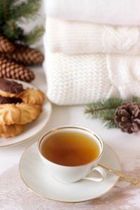 冬季成分与茶和饼干的背景下的地毯或套衫, 球果和冷杉分行