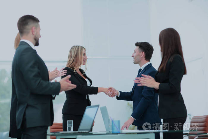 握手的商业伙伴和办公室业务团队会议
