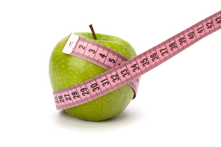 苹果带卷尺。 健康的生活方式概念。