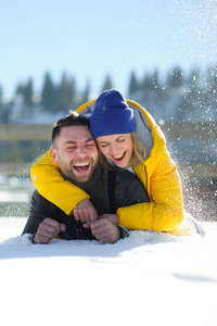 欢快的年轻夫妇躺在雪地上图片