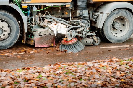 工作橙色街道清扫车在街道上工作清洁秋季树叶