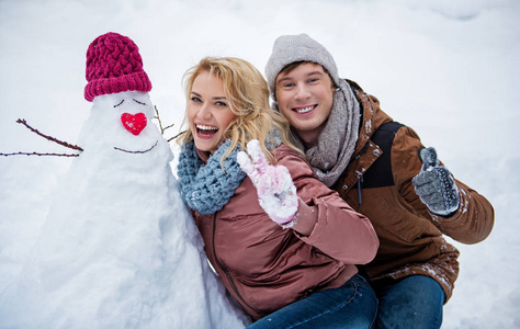 快乐的年轻人和女人在冬天玩雪