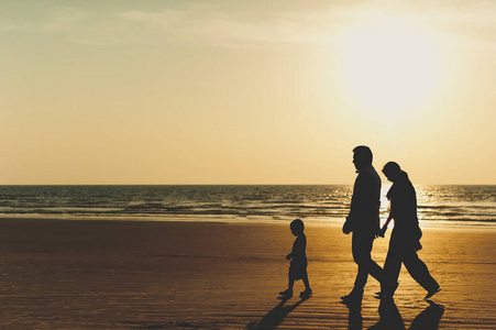 人的剪影.走在海边.游客前往亚洲.一家人在果阿度假照片