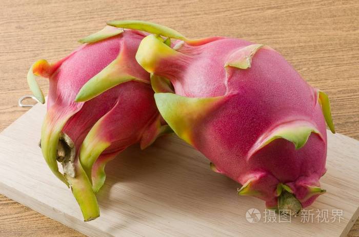 在木托盘上的两个成熟火龙果