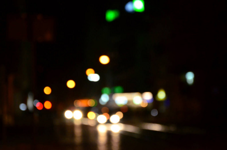 道路上的交通模糊的夜间场面。弥散的汽车与发光的车灯行驶的形象。散景艺术