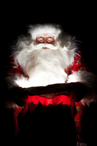 圣诞老人坐在圣诞房间和寻找进袋子